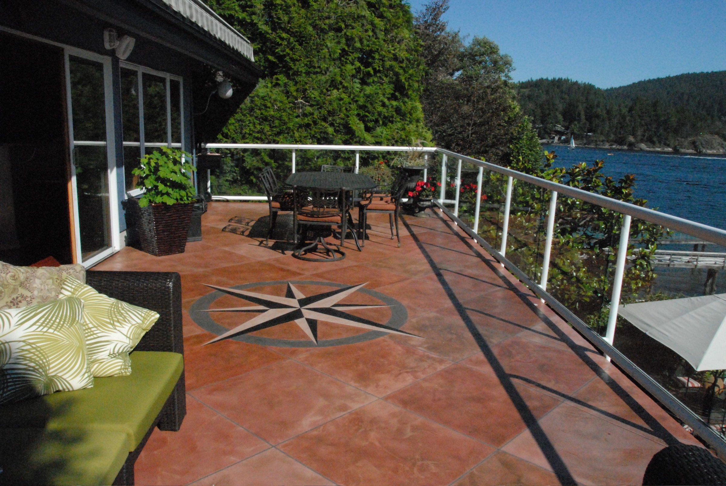 Waterproofed deck overlooking waterfront with glass railings and dark slate-toned StoneCraft surface