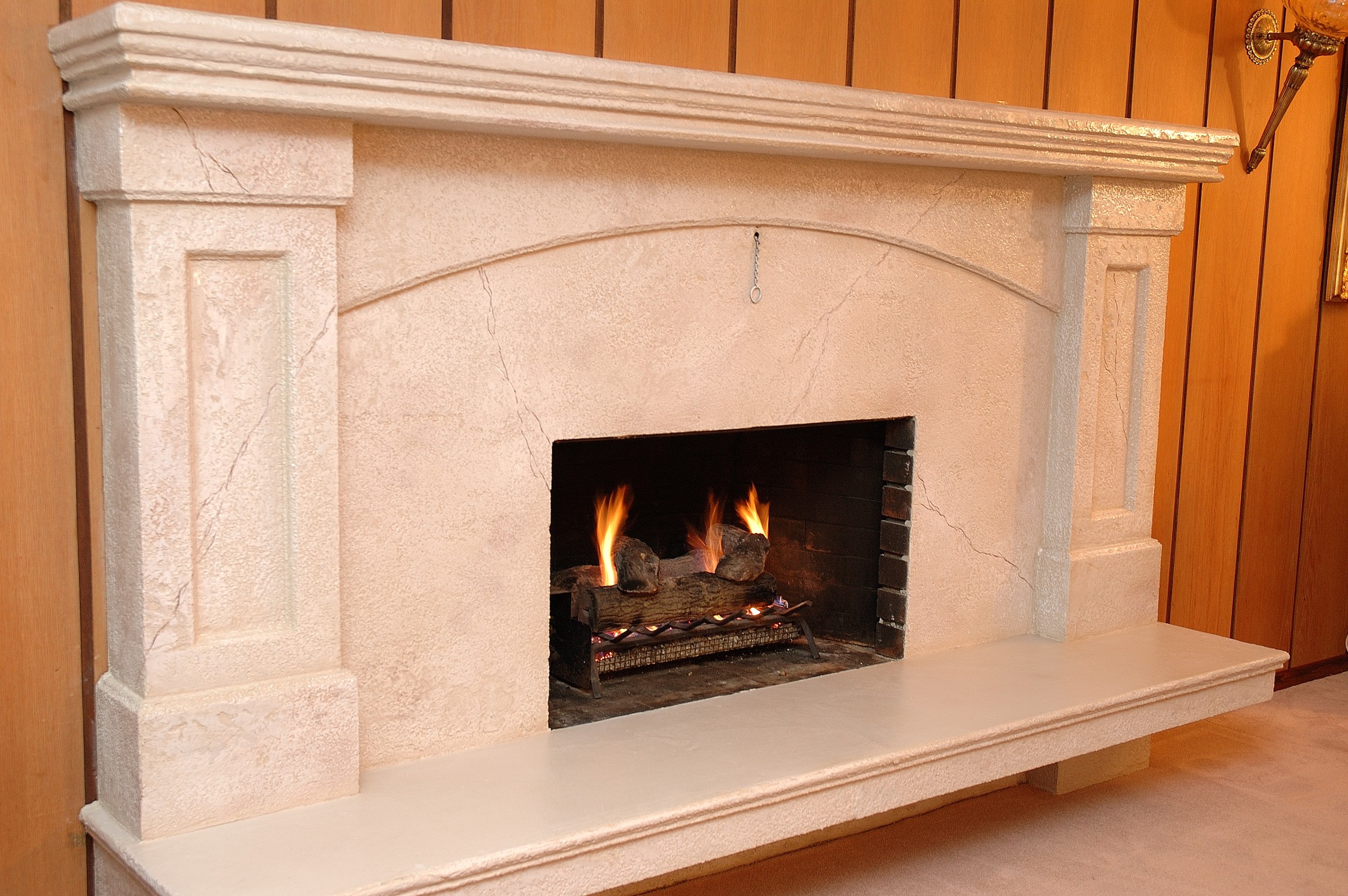 Classic StoneCraft stone hearth with traditional mantel and burning fire