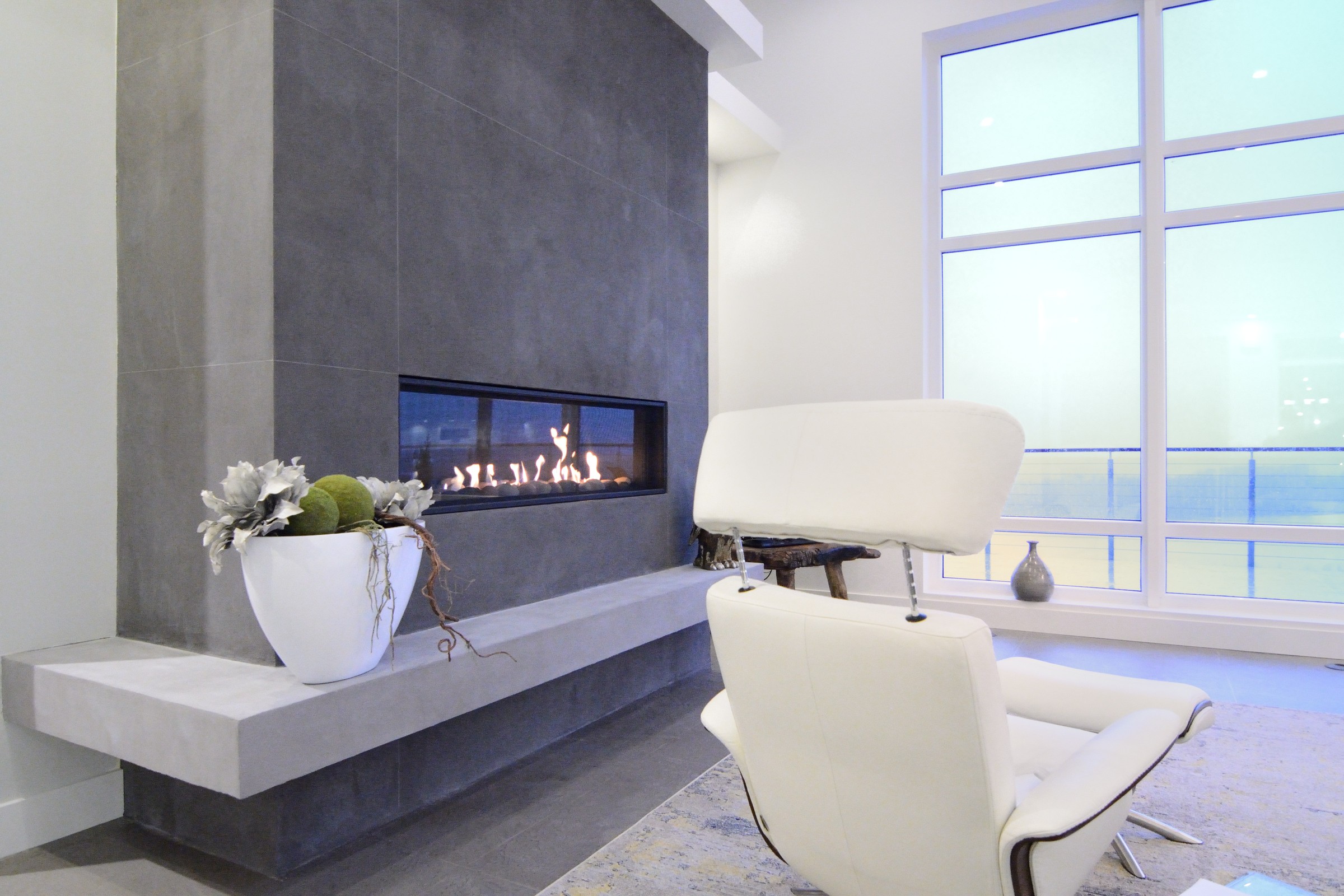 Stunning modern floor-to-ceiling StoneCraft fireplace with linear flame and panoramic windows