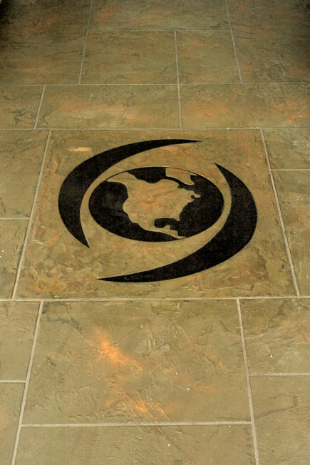 Custom globe and swirl logo inlaid in StoneCraft slate floor