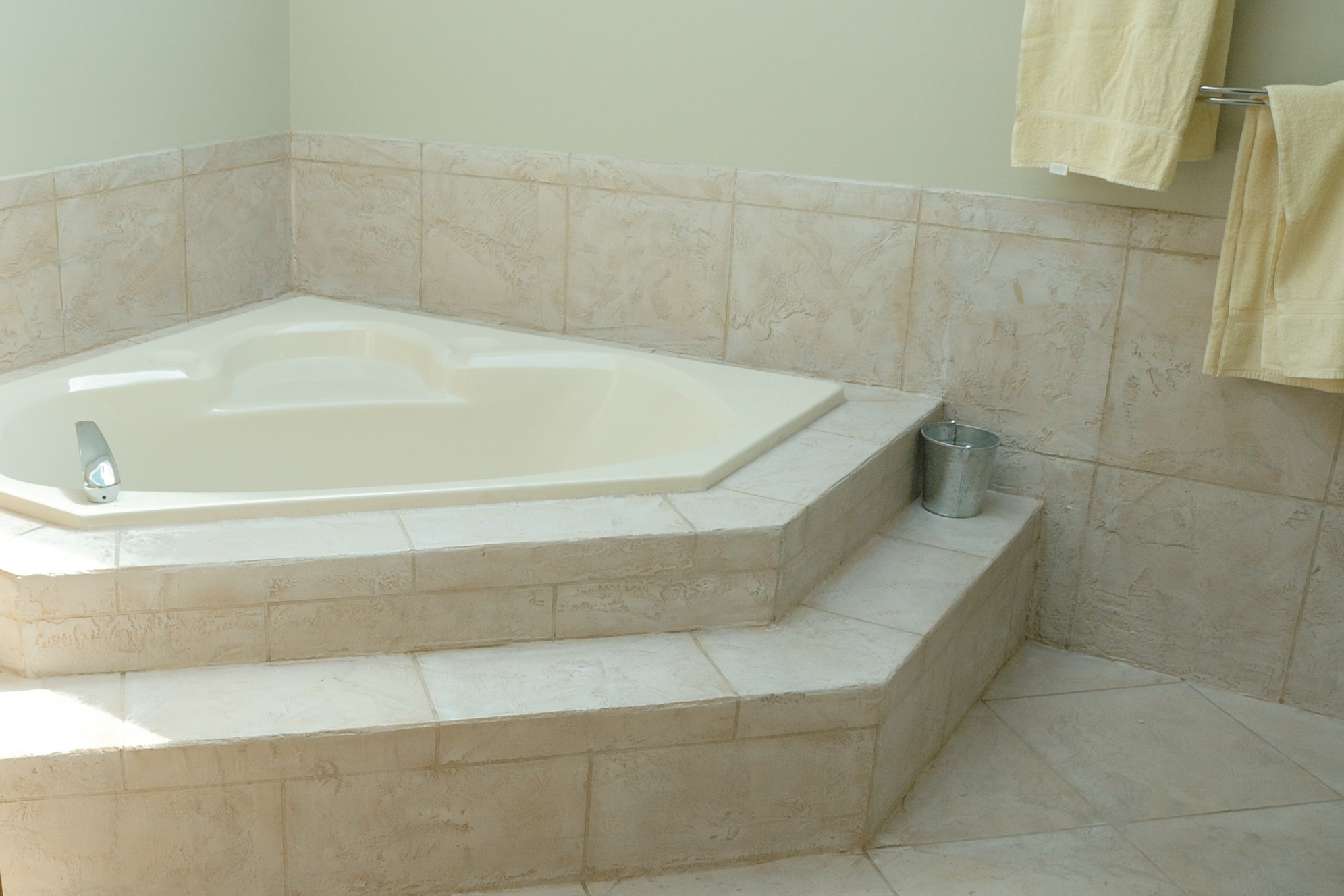 StoneCraft bathroom with matching walls, tub surround, and floor