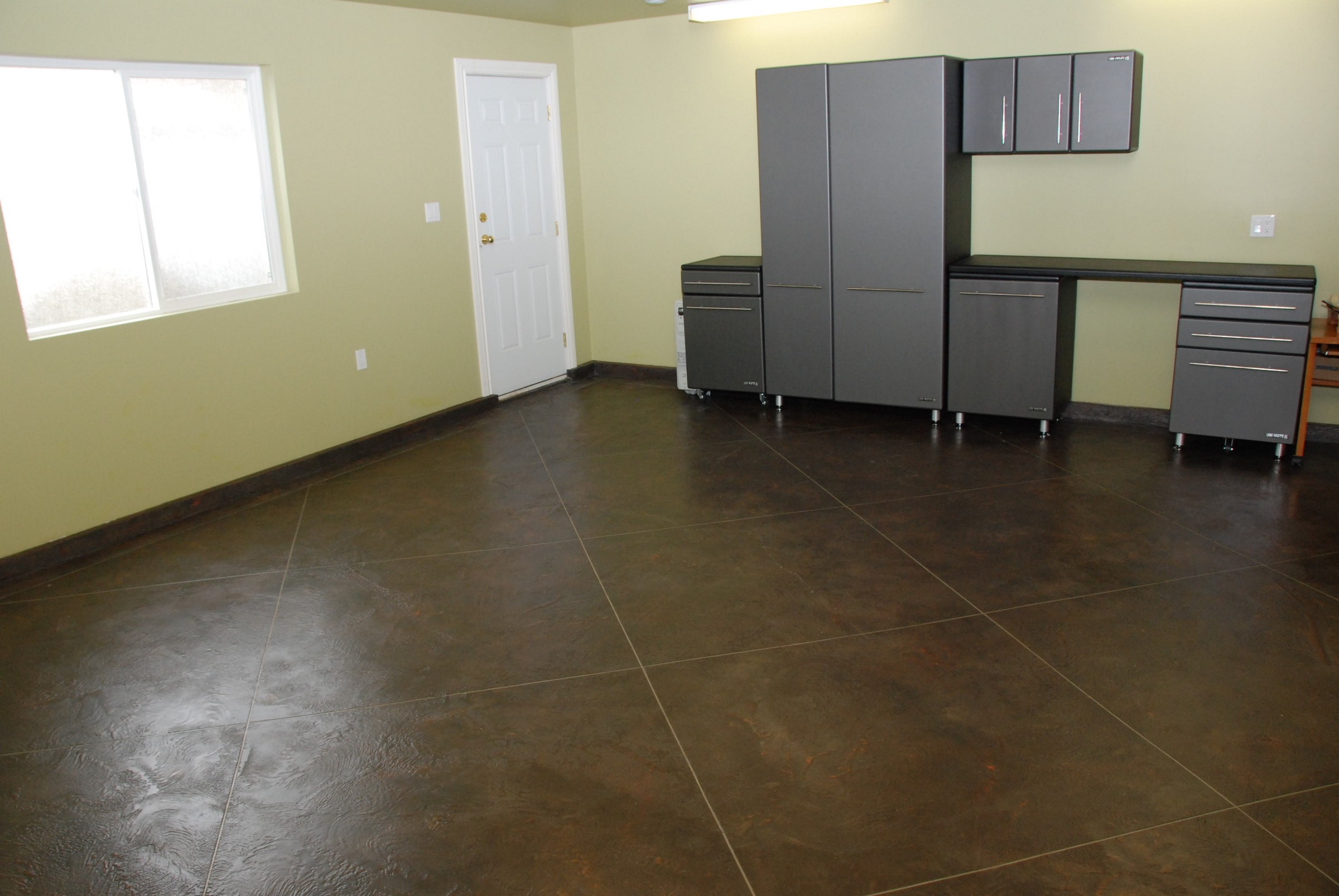 Waterproofing system applied to garage floor with decorative dark tile pattern